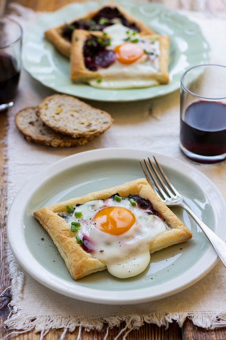 Puff pastry mini tarts with beetroot, egg and chieve, blach pepper, bread, red wine