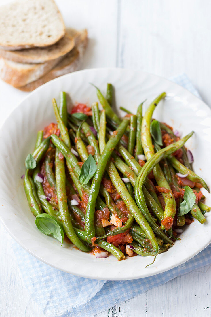 Fasolakia lathera - greek dish, green beans in tomato sauce with red onions and basil, bread