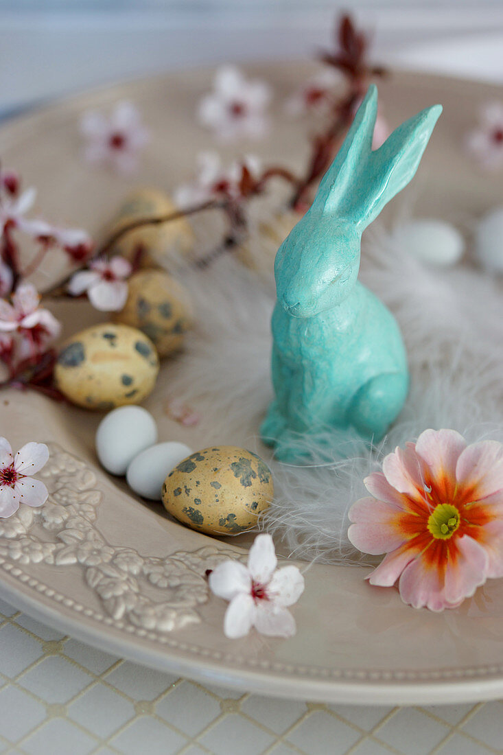 Kleine Osterdeko mit Osterhase, Ostereiern, Primelblüte und Zweig von Blutpflaume