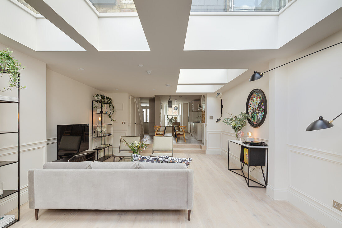 Open-plan, elongated, white interior with skylights