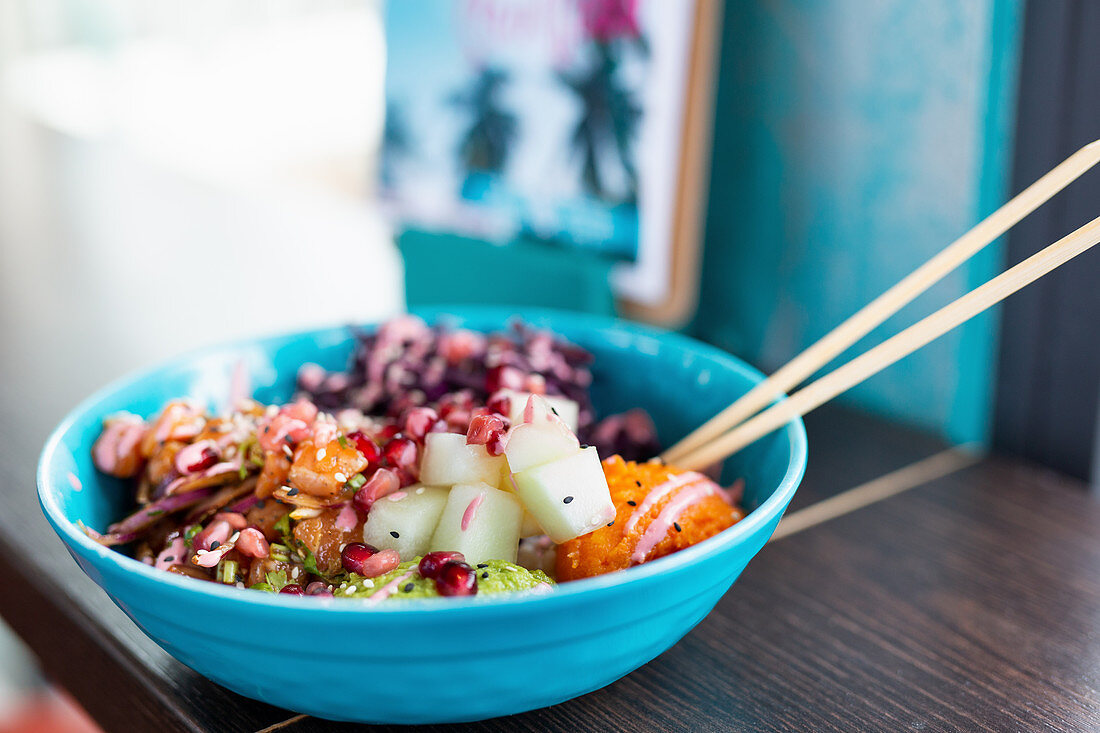 Poké bowl with salmon, mashed sweet potatoes and pomegranate seeds