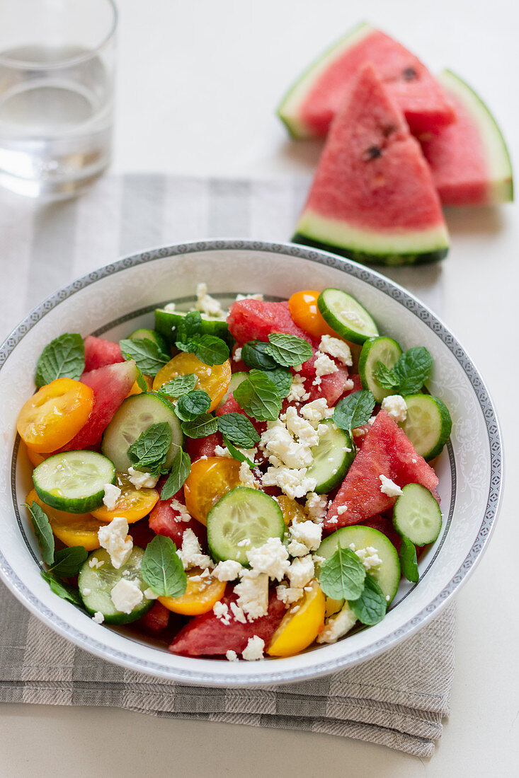 Wassermelonensalat mit Gurke, gelben Tomaten, Minze und Feta