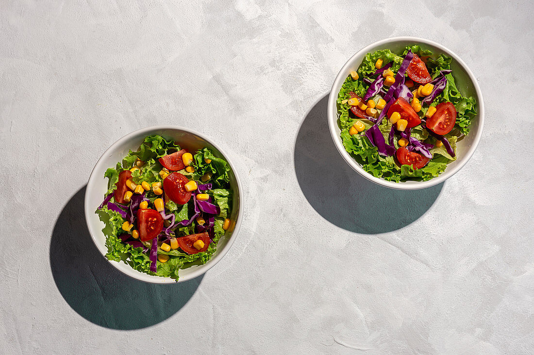 Veganer Salat mit Kirschtomaten, roten Zwiebeln und Mais