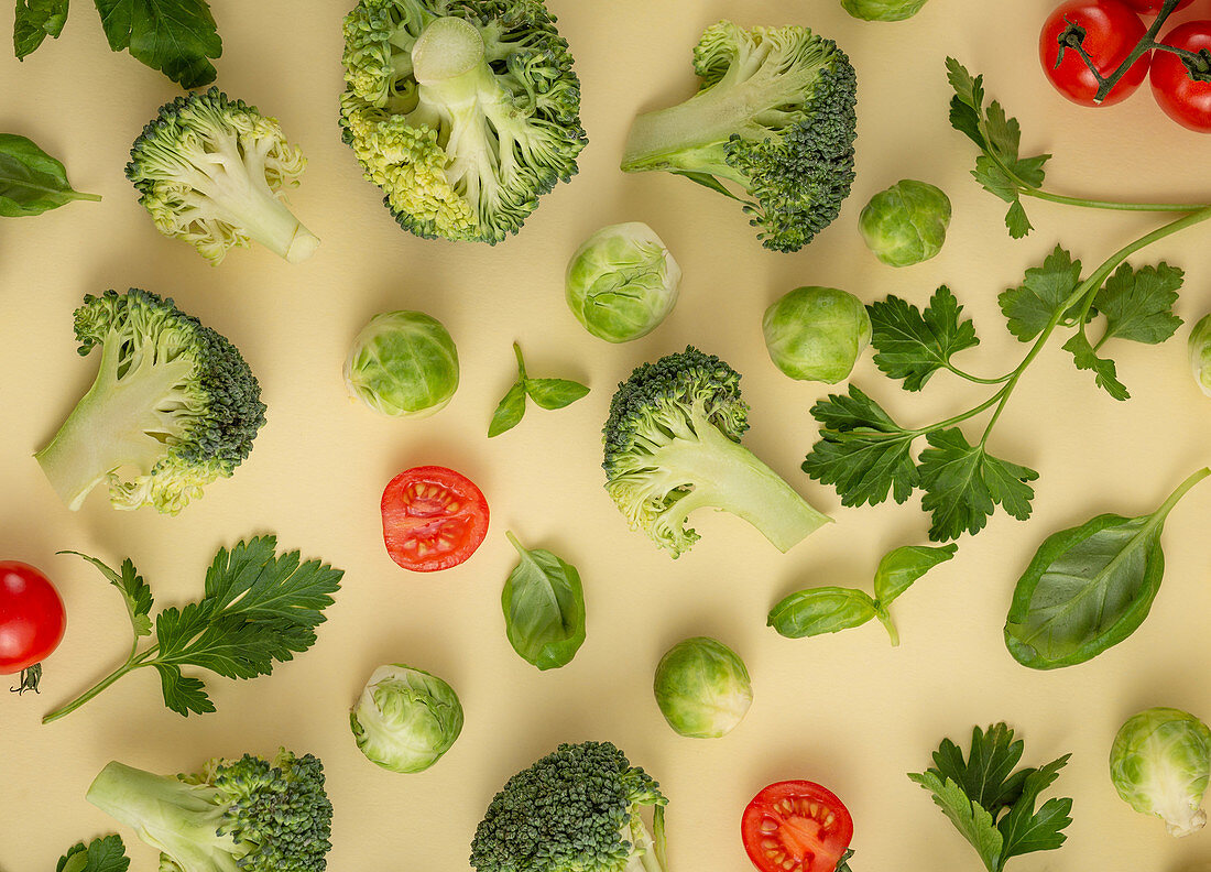 Gemüsestilleben mit Brokkoli, Rosenkohl, Gurke, geschnittenen Tomaten und Kräutern