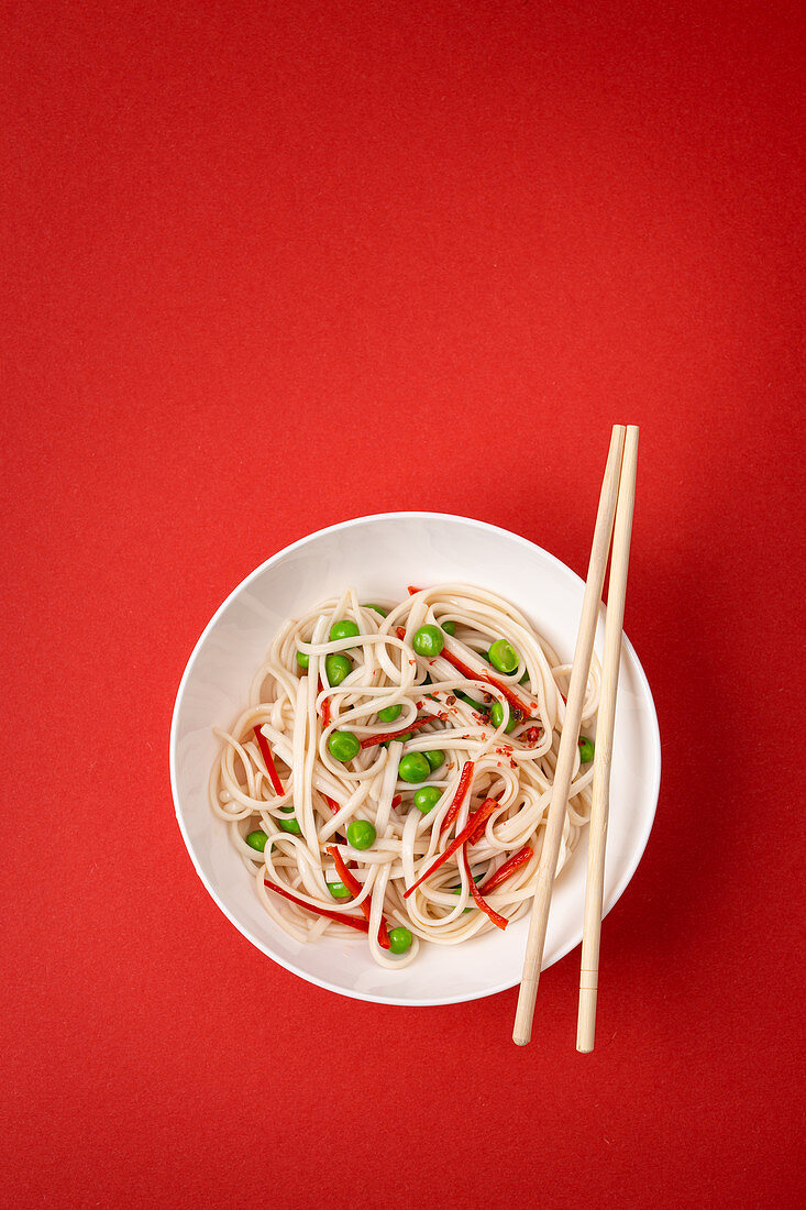 Asian noodles with vegetables, green peas and red pepper
