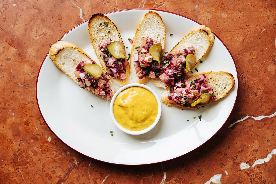 Crostini mit Zwiebel-Mett, Essiggurke und Senf