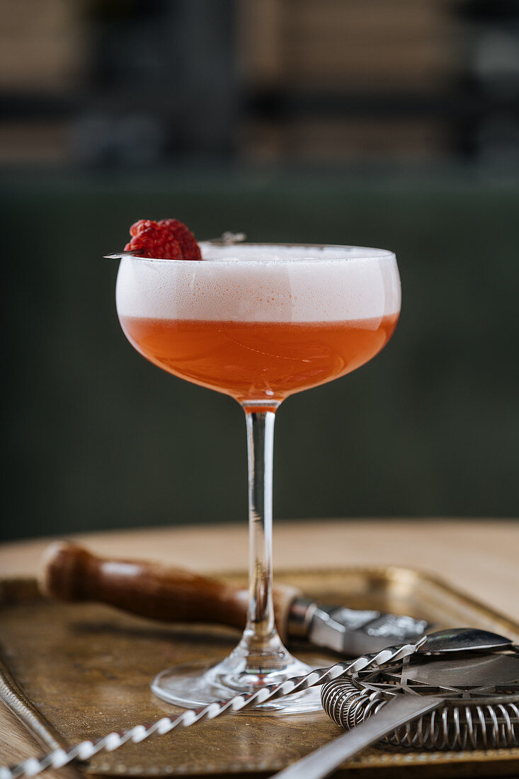 Roter Cocktail mit Schaum und Himbeerspiess