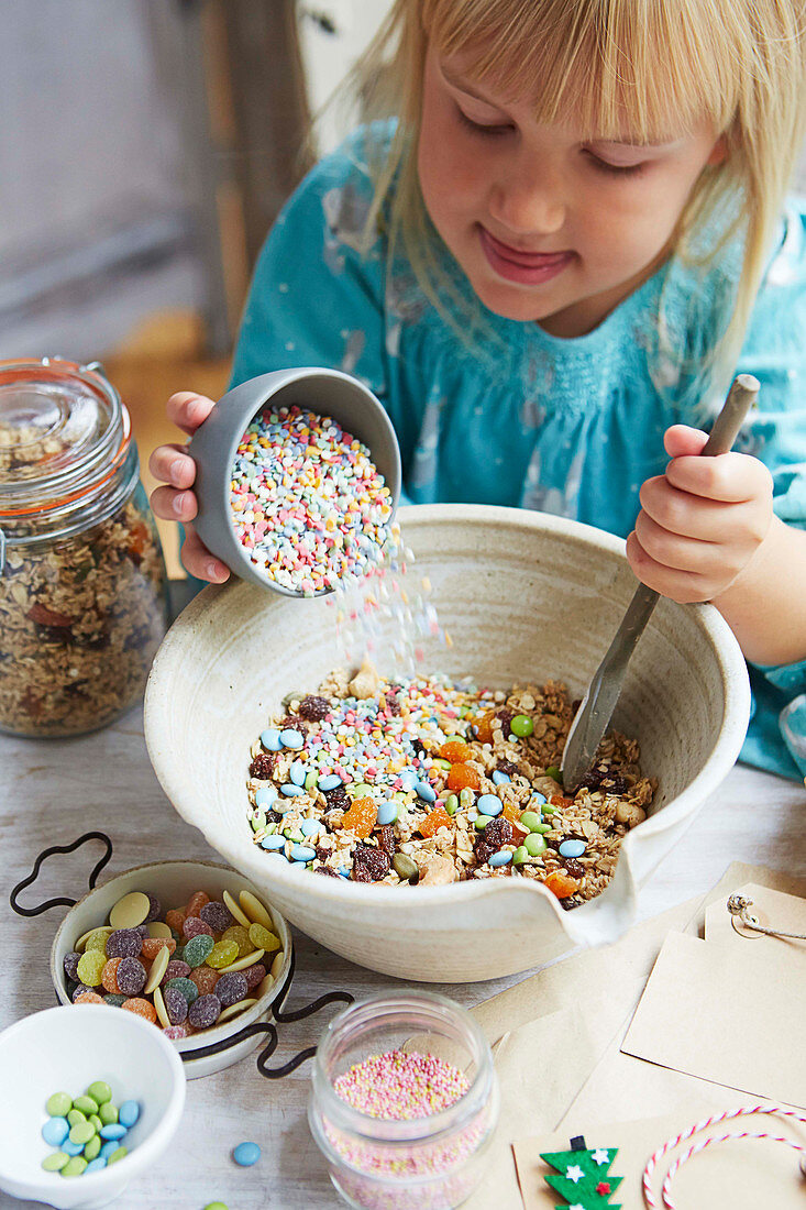 Mädchen vermischt Cerealien mit Süßigkeiten