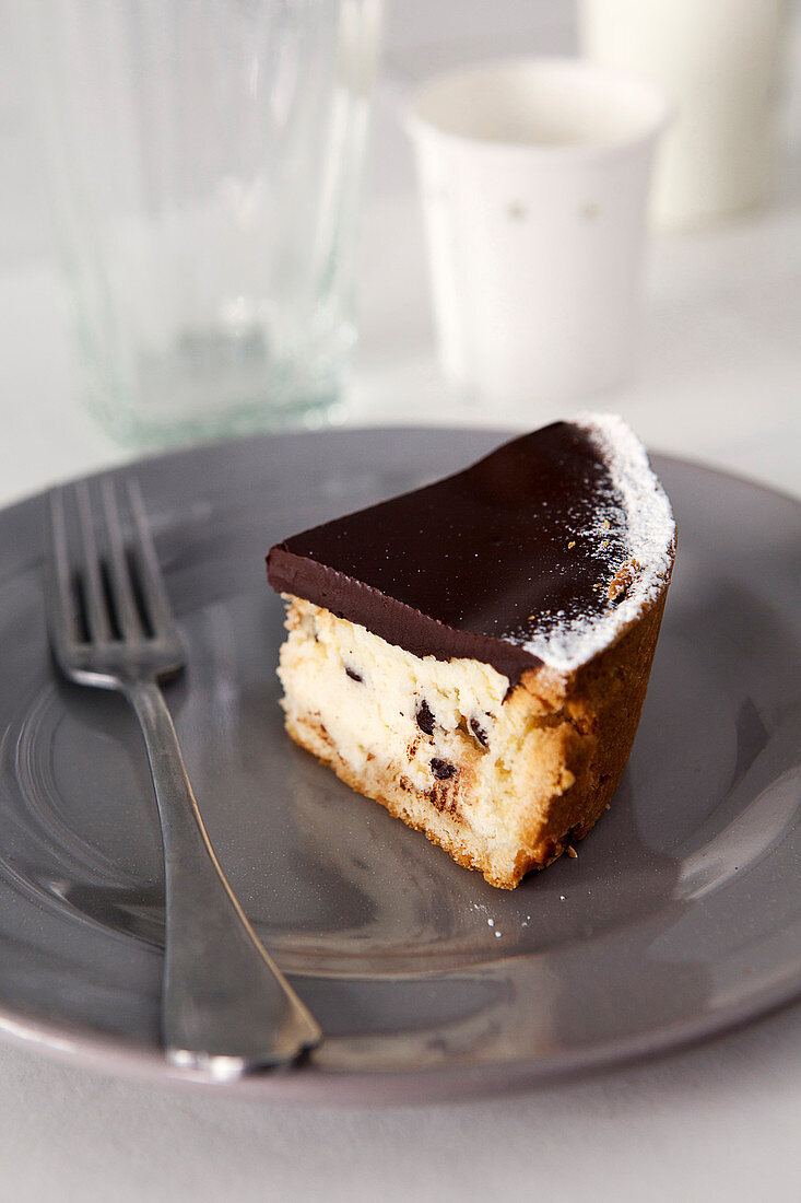 Ein Stück Käsekuchen mit dunkler Schokolade