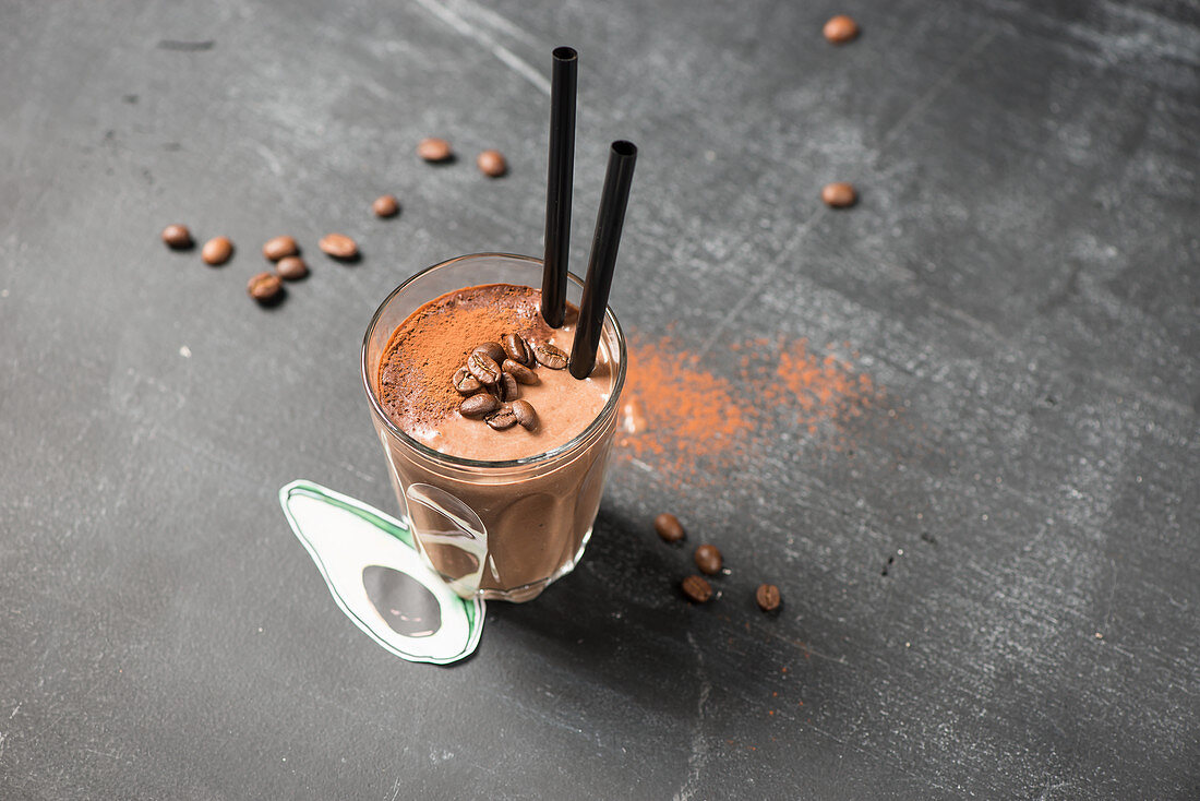 A coffee and chocolate smoothie with a straw in a glass