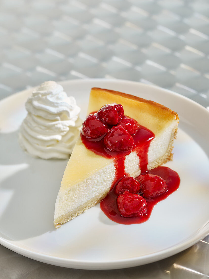 Ein Stück Himbeer-Käsekuchen mit Schlagsahne