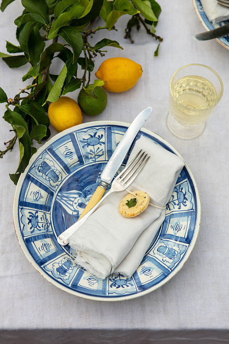 Tischgedeck mit Zitronenplätzchen dekoriert und Zweig mit Zitronen