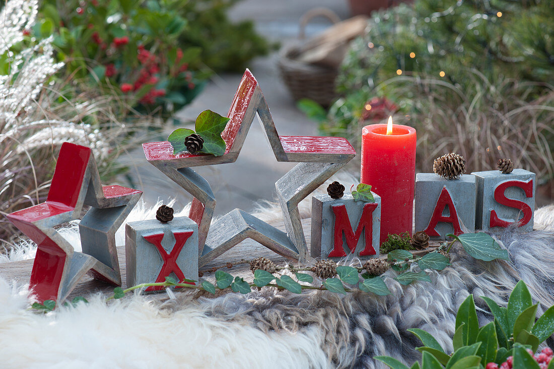 Modern Christmas decoration with stars, candle and XMAS message