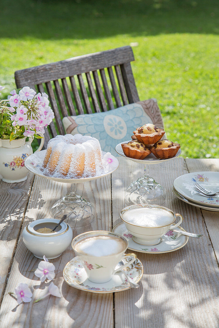 Table set for afternoon coffee with vintage-style crockery and DIY cake stands