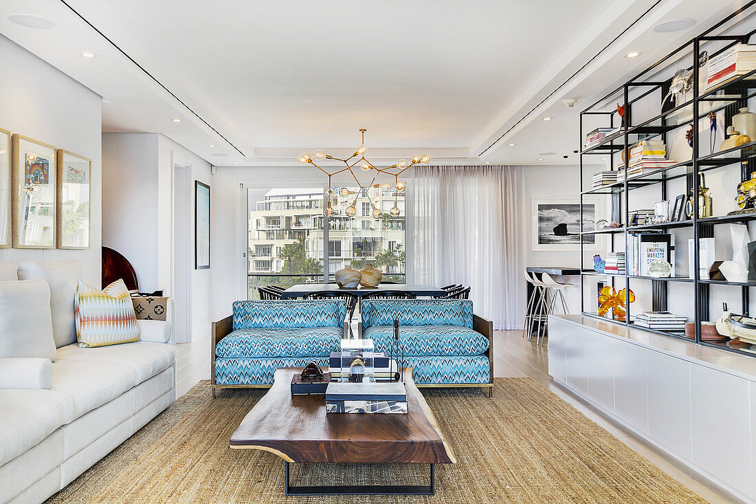 Shelves, coffee table and turquoise sofa in bright living room