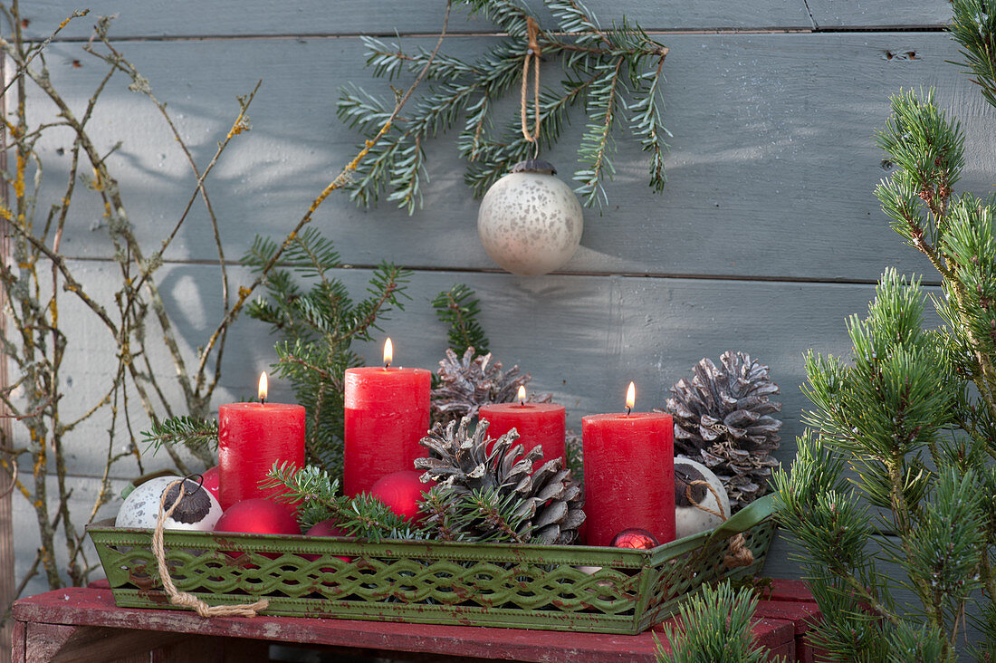5-minute Advent wreath for the terrace: red candles, cones, fir branches and Christmas tree balls on a metal tray