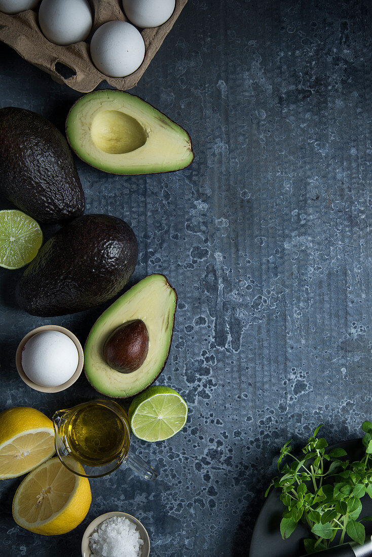 Ingredients for a low-carb breakfast: eggs, avocado and herbs