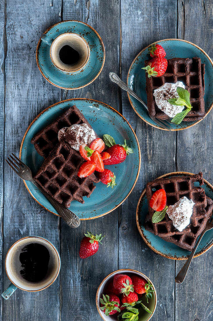 Chocolate waffles with strawberries and sour cream