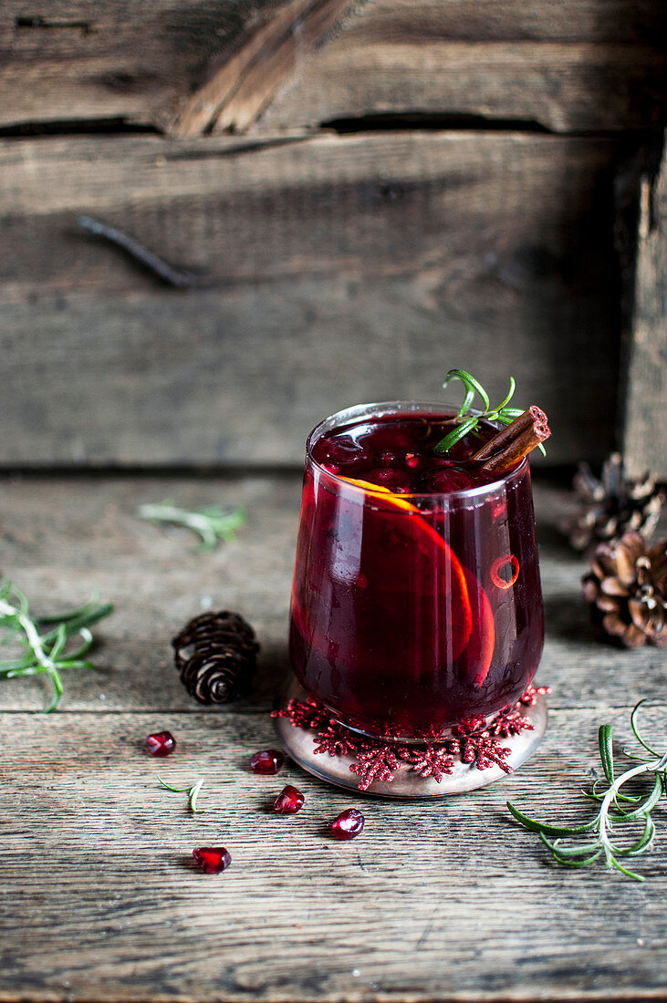 Cherry and pomegranate mocktail with orange, cinnamon and rosemary