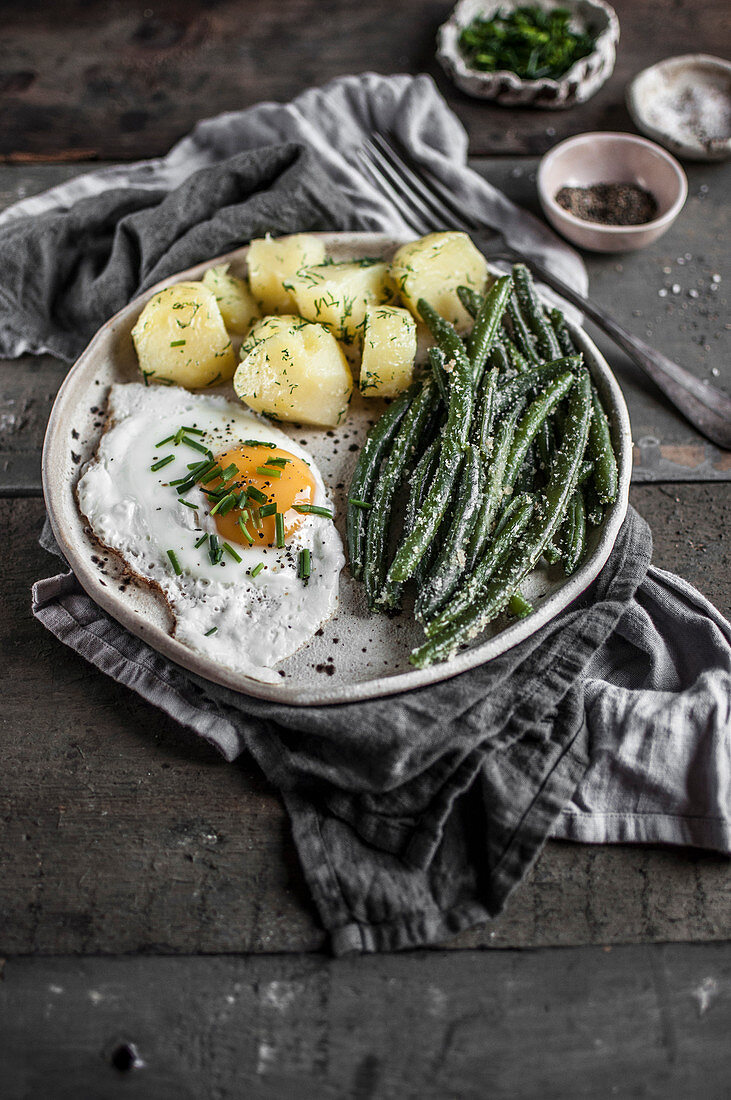 Vegetarischer Lunch mit Spiegelei, Pellkartoffeln und grünen Bohnen mit Bröselbutter