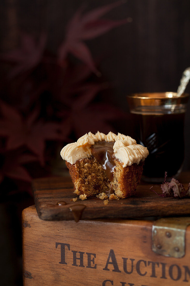 Cut into sticky toffee cupcake with sauce dribbling down it