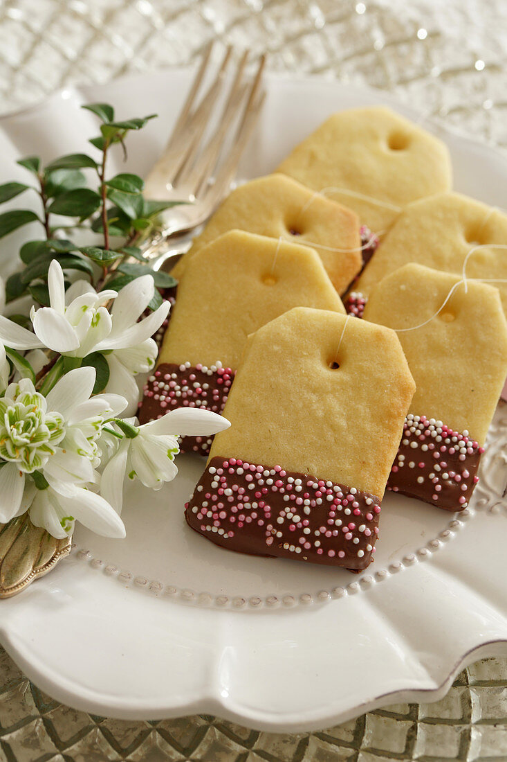 Teabag shaped shortbread biscuits decorated with chocolate glaze and sprinkles