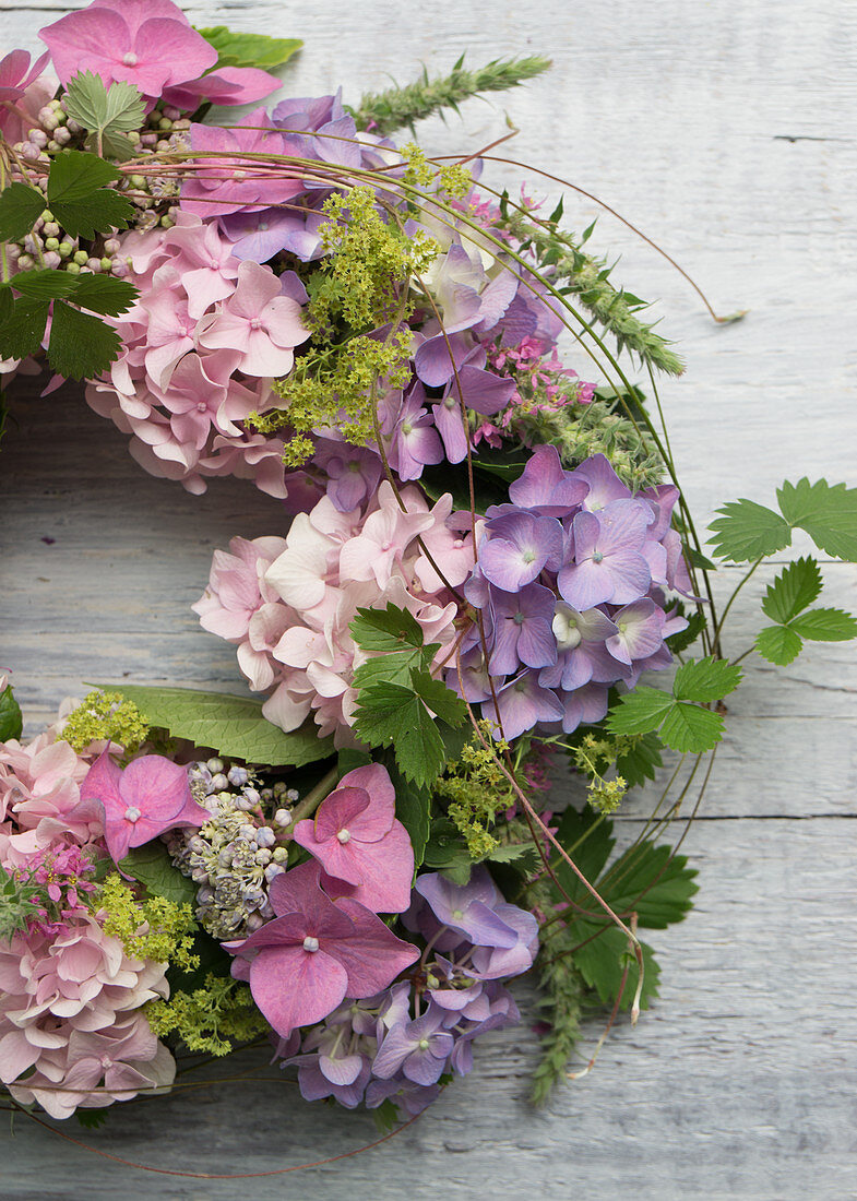 Kranz aus Blüten von Hortensien, Frauenmantel und Ranken von Walderdbeere