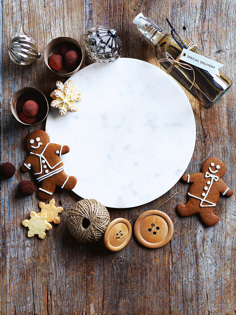 Christmas biscuits, sweets and decorations around a marble plate