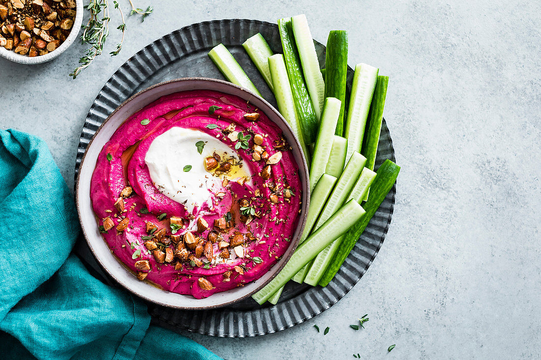 Pink beet cashew hummus swirled with garlic yogurt tahini and sprinkled with roasted almond za’atar.