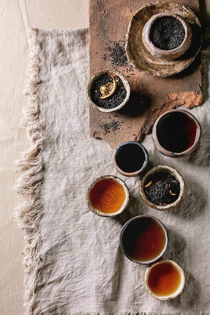 Variety of hot and dry tea green and black in traditional and wabi sabi style fireclay ceramic craft cups and bowls