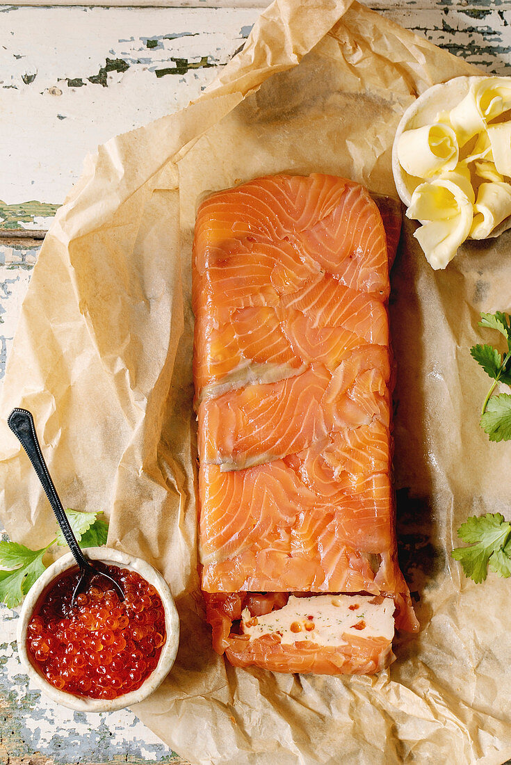 Red salmon caviar in ceramic bowl and homemade salmon terrine served with butter