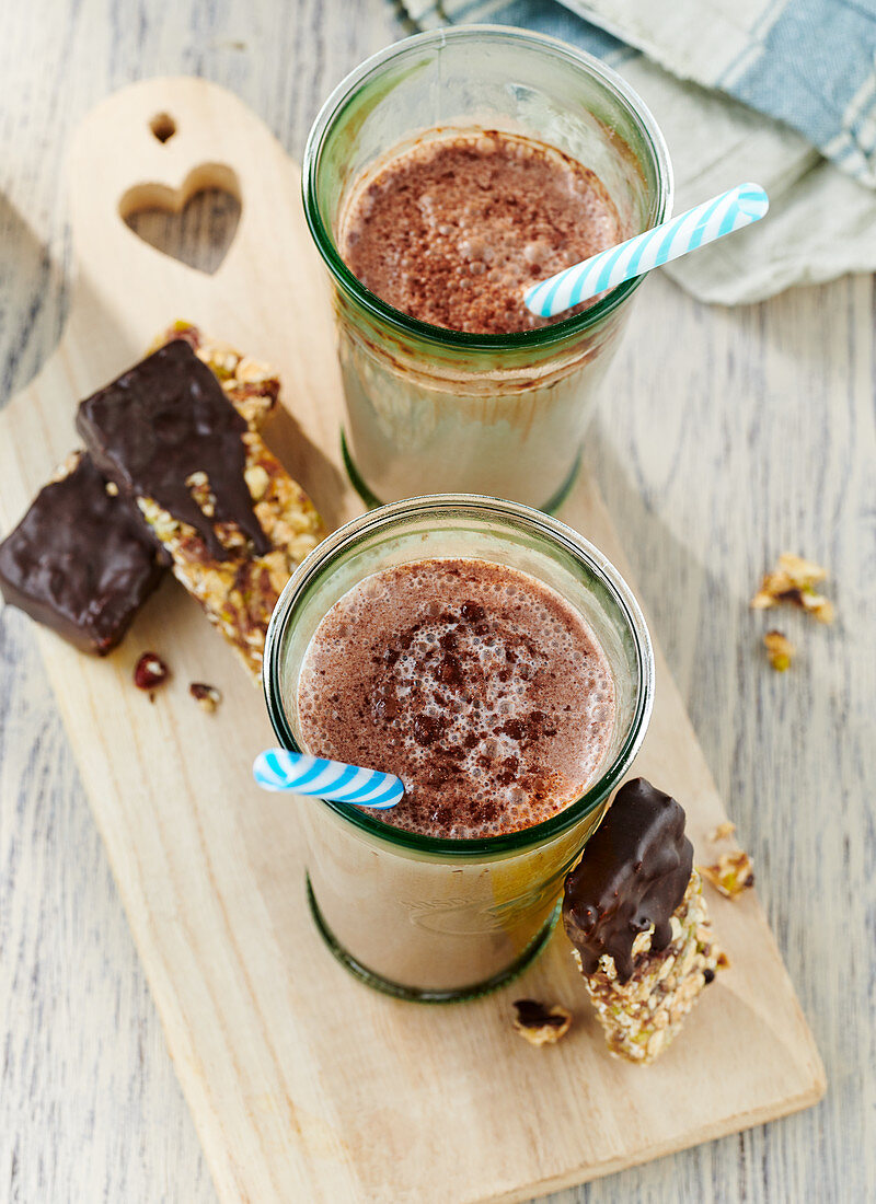 Hot chocolate in glasses with homemade muesli bars with chocolate glaze