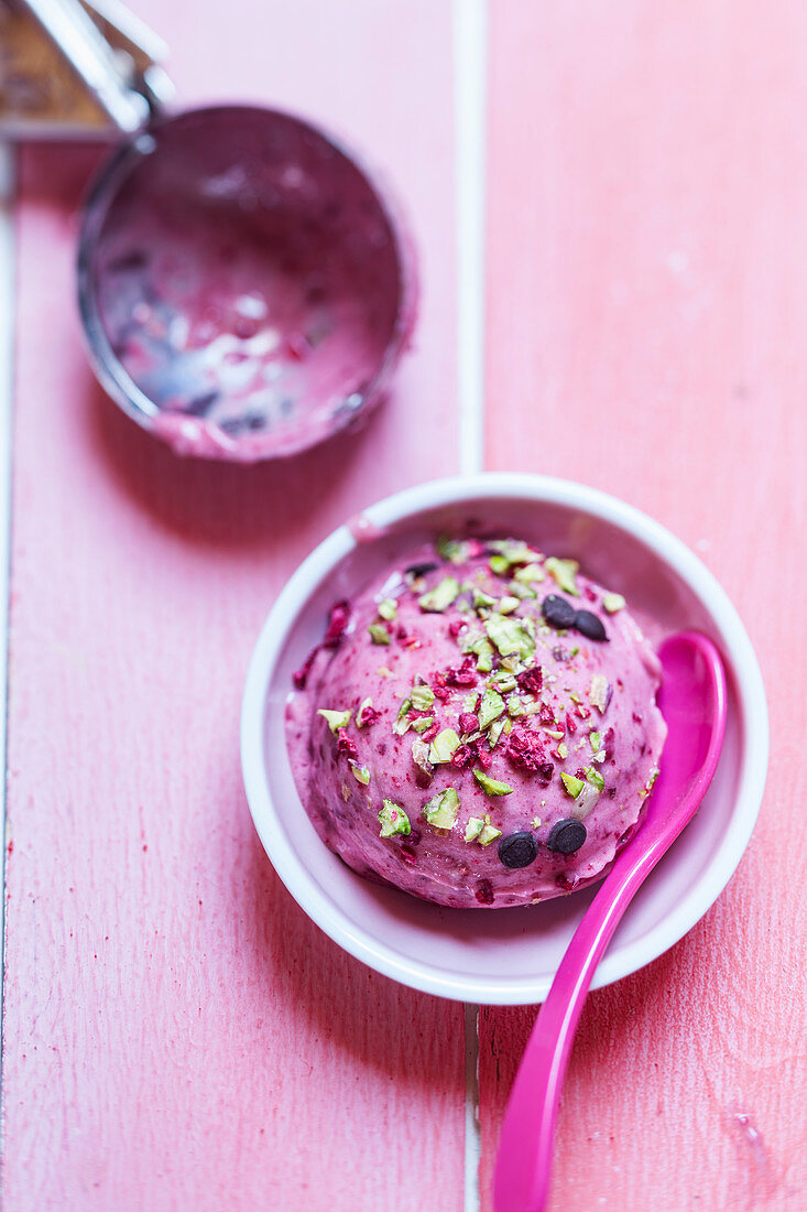 Raspberry nice cream with chocolate chips and pistachio nuts