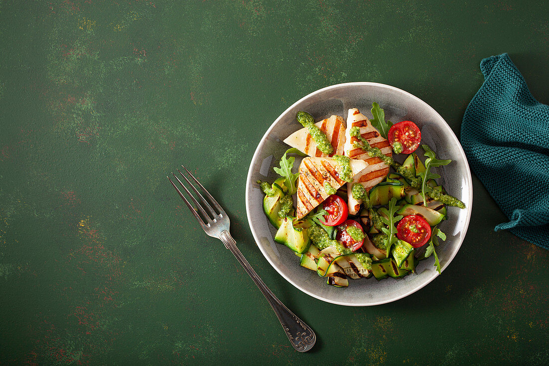 Courgette salad with grilled halloumi, tomatoes and pesto
