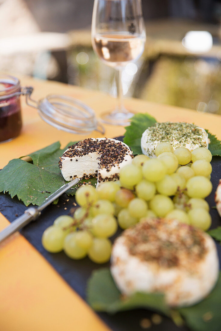 Ziegenfrischkäse und Weintrauben auf Weinblättern serviert