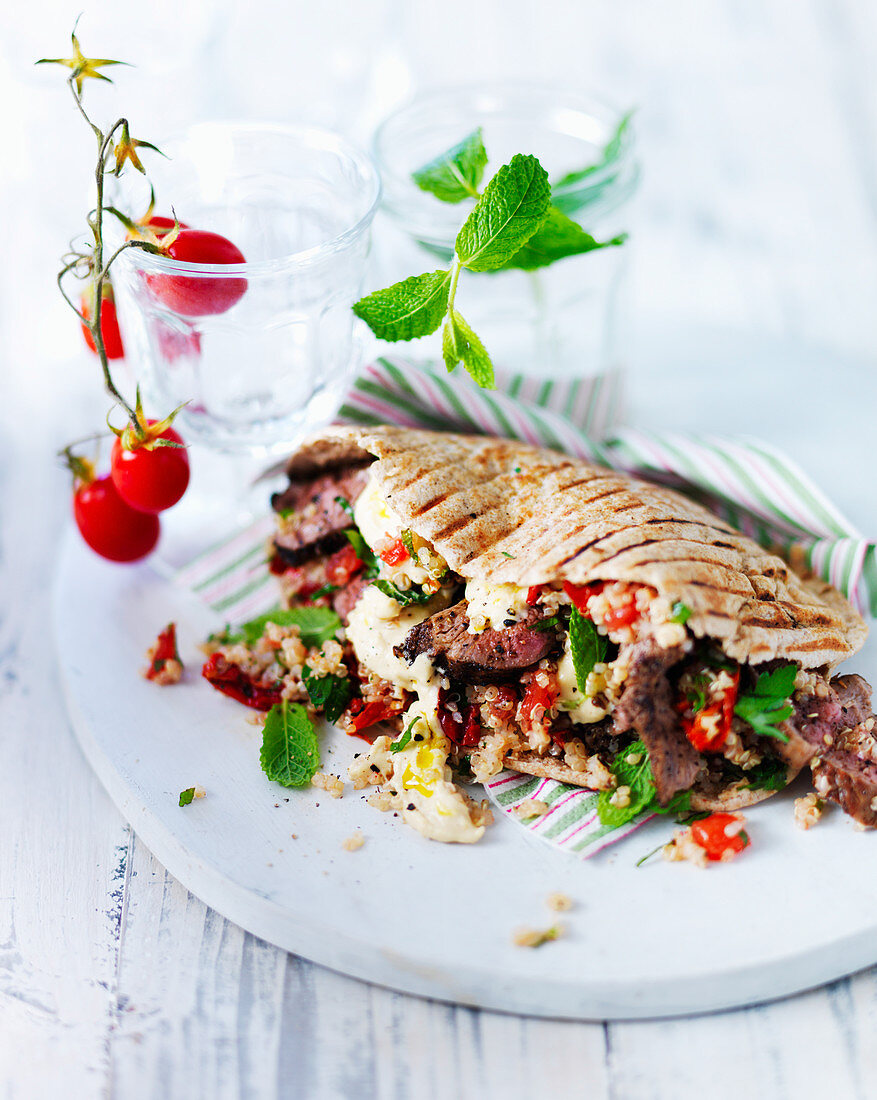 Pitta flatbread with lamb, mint, quinoa, hummus and red peppers
