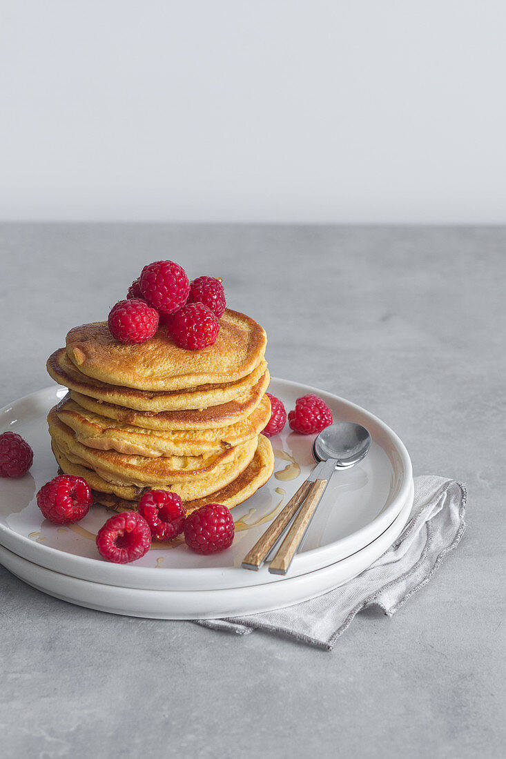 Stack of tasty pancakes with ripe raspberries