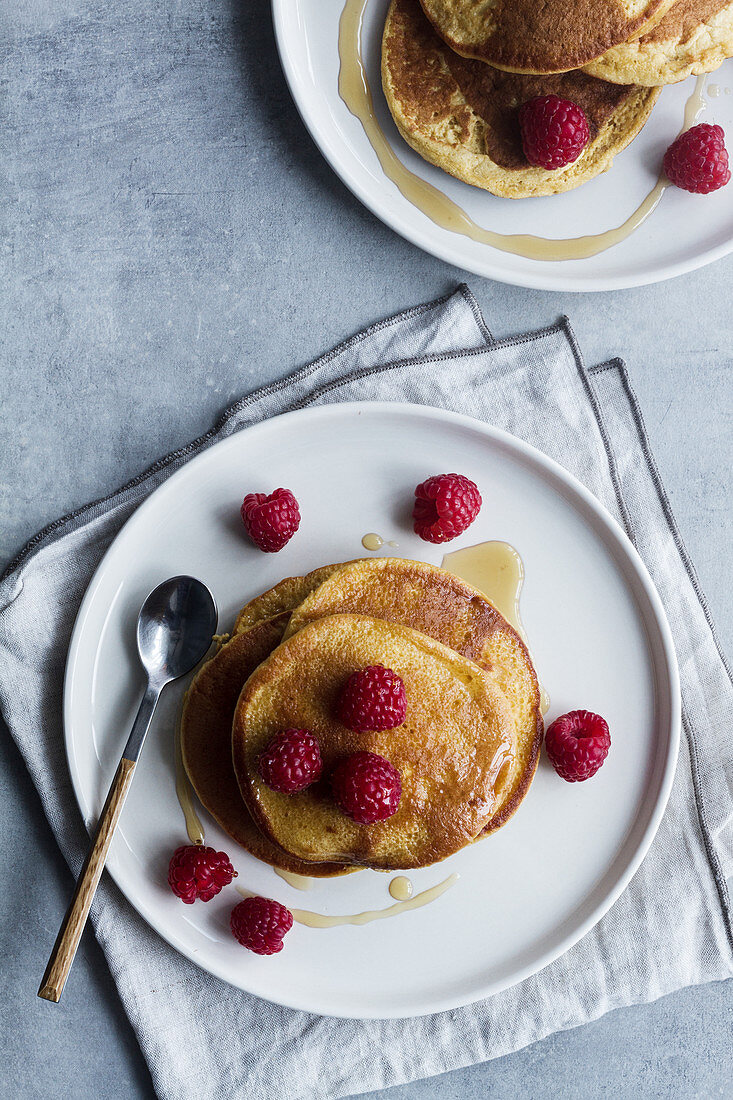 Stack of tasty pancakes with ripe raspberries