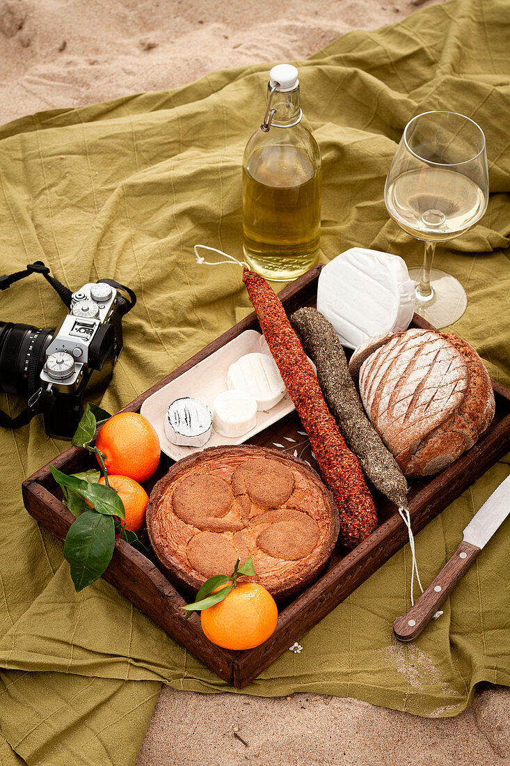 Holztablett mit Apfelpie, Käse, Salami, Brot und Früchten