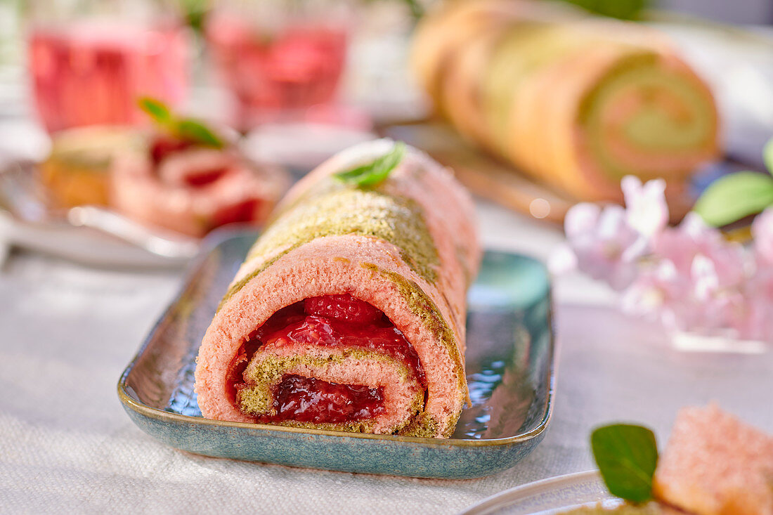 Strawberry and pistachio roulade on a garden table