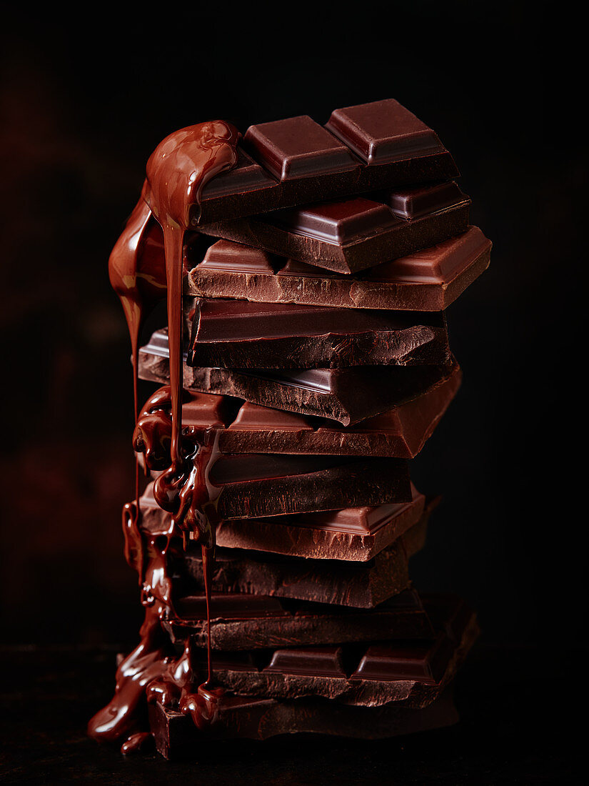 Gestapelte Schokoladenstücke mit schmelzender Schokolade