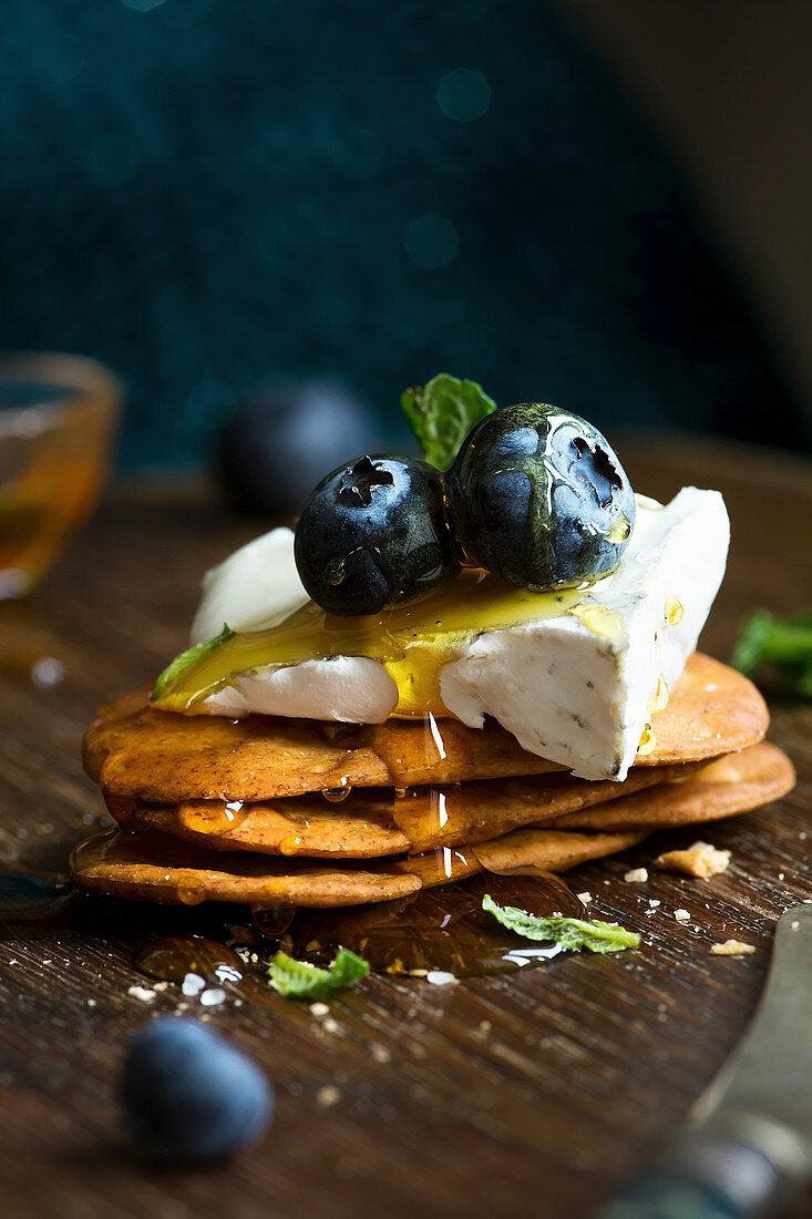 Camembert Cheese on savoury biscuits with honey and blueberries