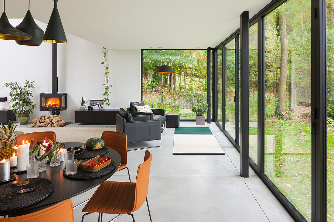 Dining table in modern, open-plan interior with glass wall