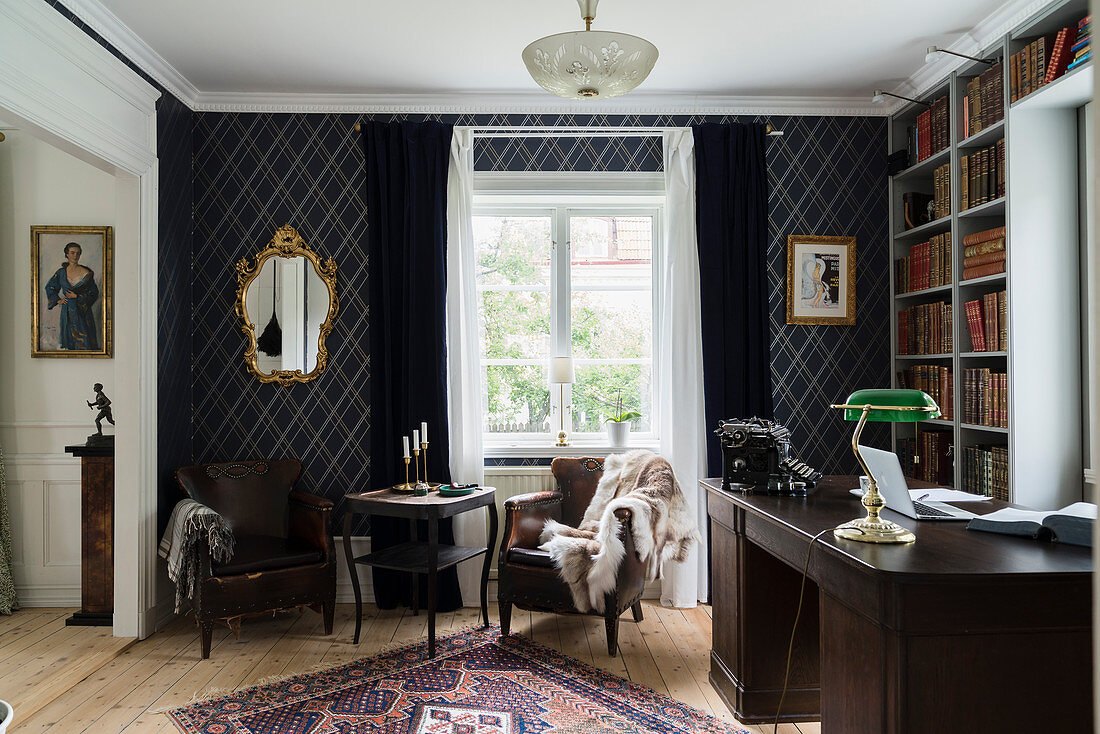 Leather armchair, dark desk and bookcase in study