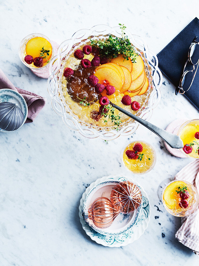 Eiskalter Punsch mit Earl Grey Tee, Gin, Weißwein, Pfirsichen und Himbeeren