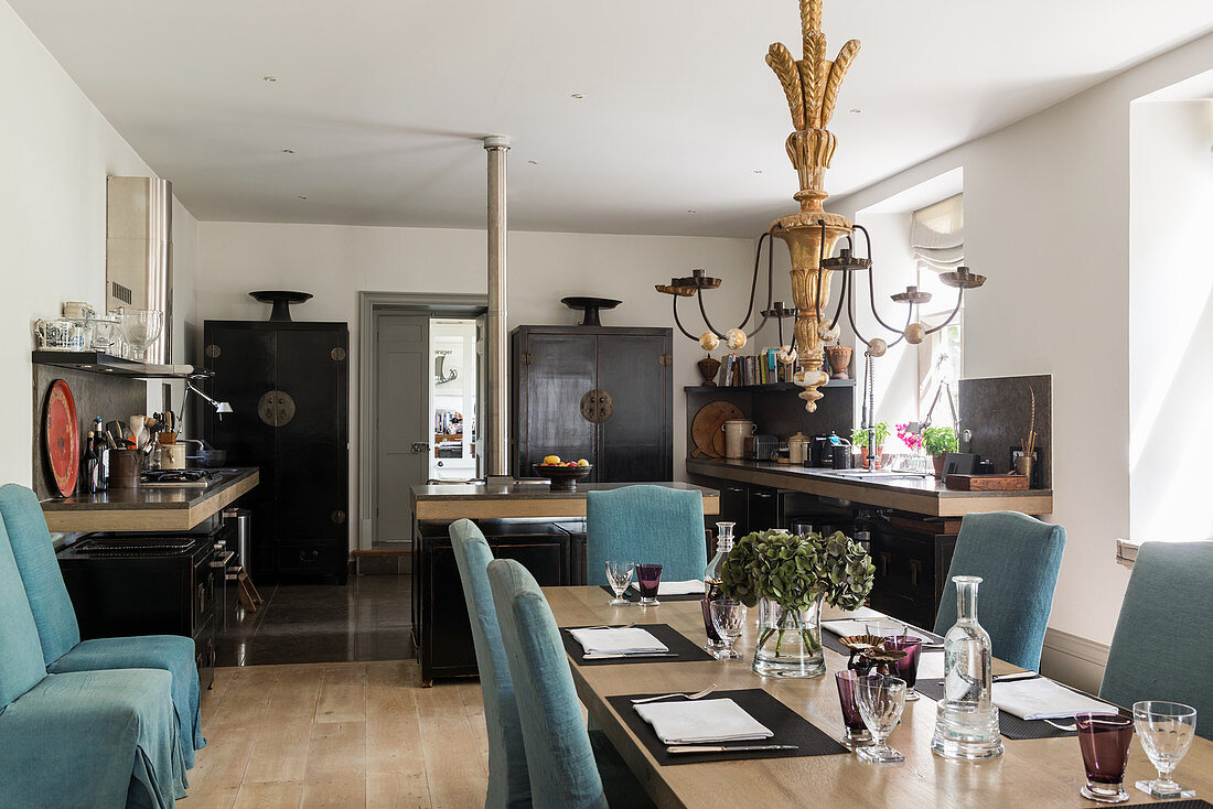 Blue loose-covered chairs around set dining table in classic kitchen-dining room