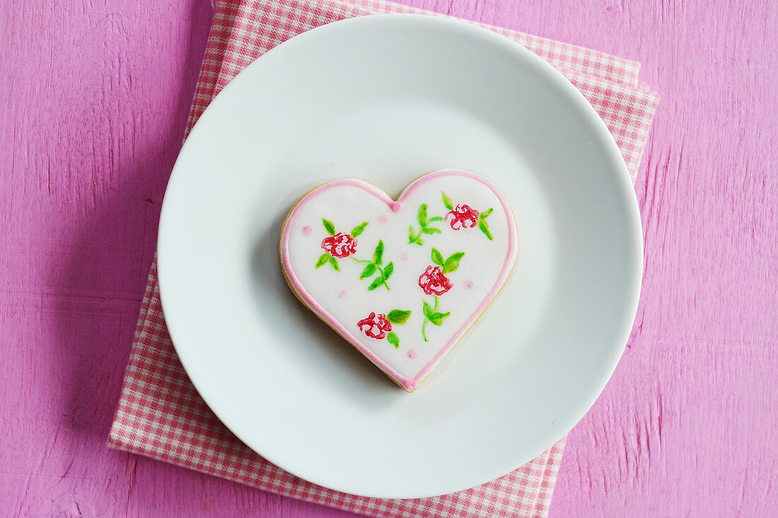 Heart cookies hand-painted with floral motifs on a plate