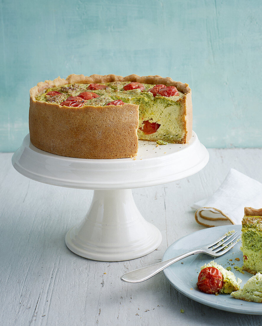 Broccoli quiche with cherry tomatoes on a cake stand