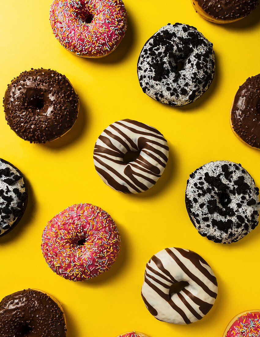 Donuts mit verschiedenen Glasuren auf gelbem Untergrund