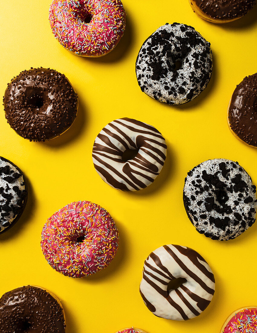 Donuts with different glazes on a yellow background